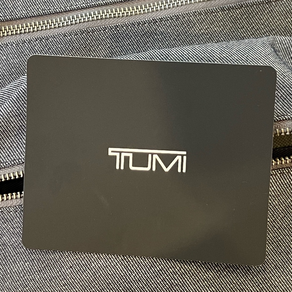 TUMI Gray and black roll top backpack. Fits over luggage handle.